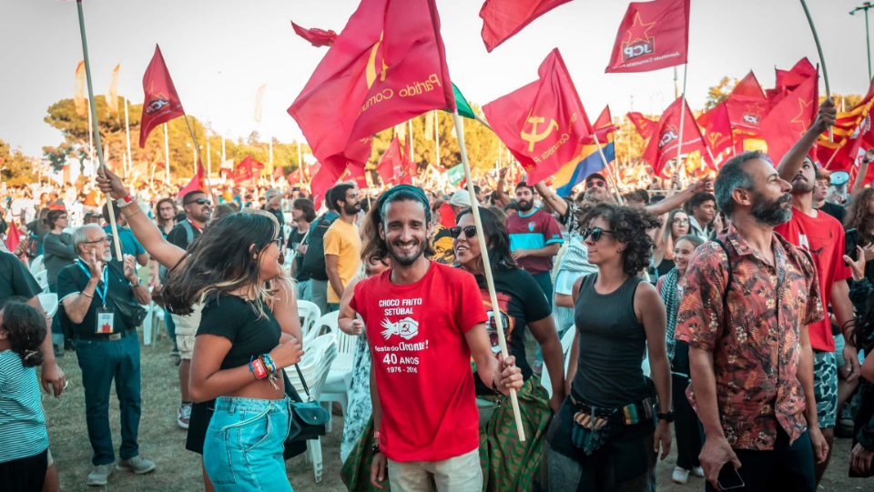 Members of the Portuguese Communist Party Youth carry flags and